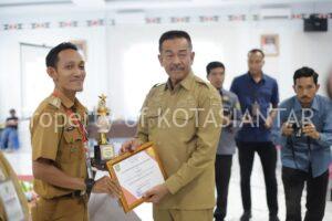 Bupati Mandailing Natal H. Saipullah Nasution, SH., MM menyerahkan Piagam dan Tropy kepada Lurah Kota Siantar Alamria Pramana, S.Pd.I., M.Pd