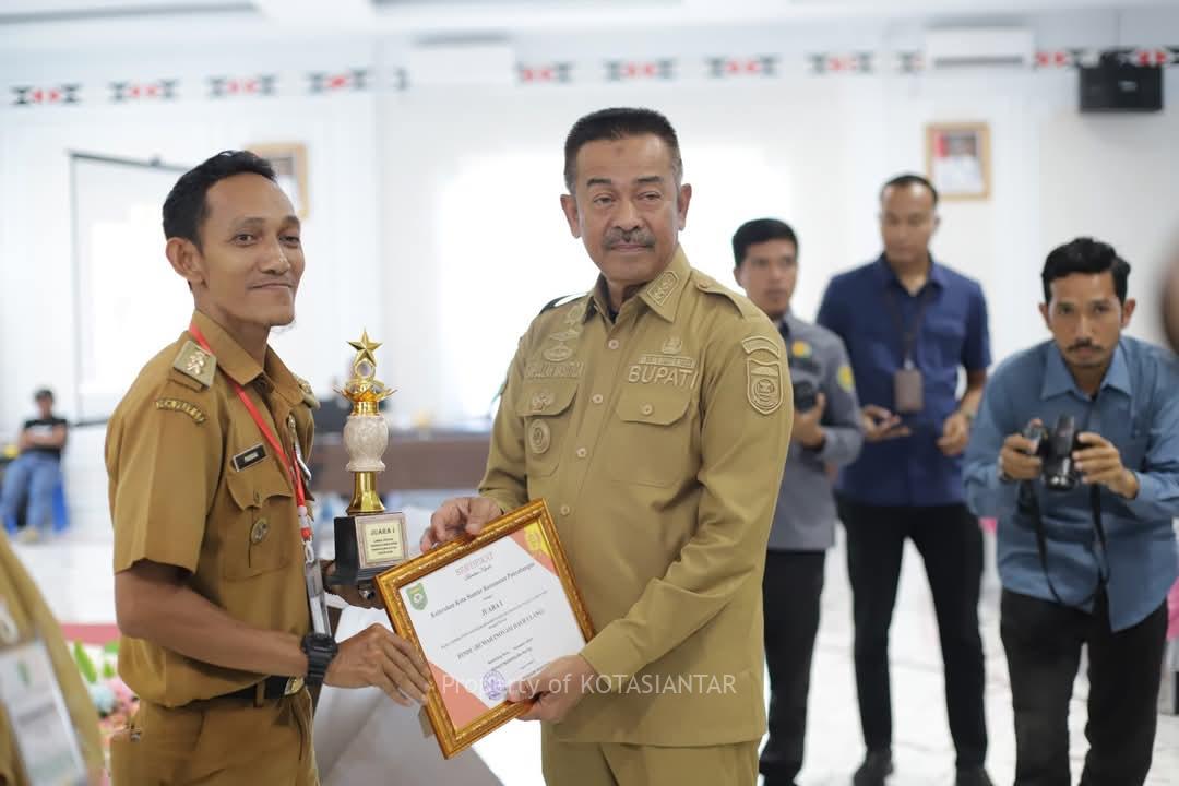 Bupati Mandailing Natal H. Saipullah Nasution, SH., MM menyerahkan Piagam dan Tropy kepada Lurah Kota Siantar Alamria Pramana, S.Pd.I., M.Pd